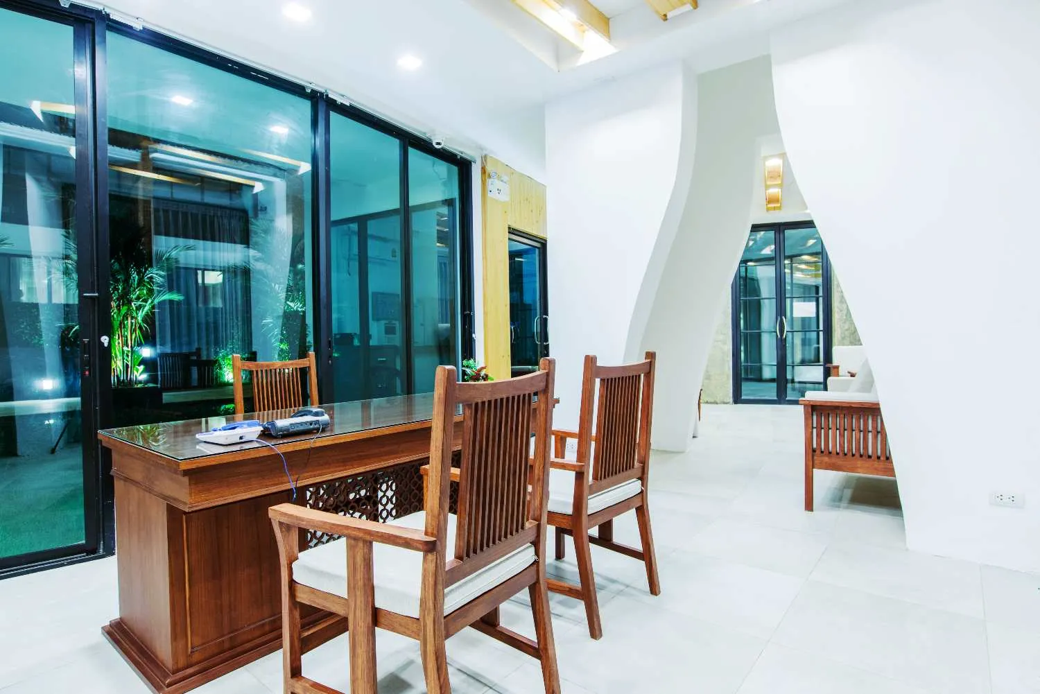 Modern hotel lobby with wooden chairs and large glass windows at Mae Hong Son Premier Hotel