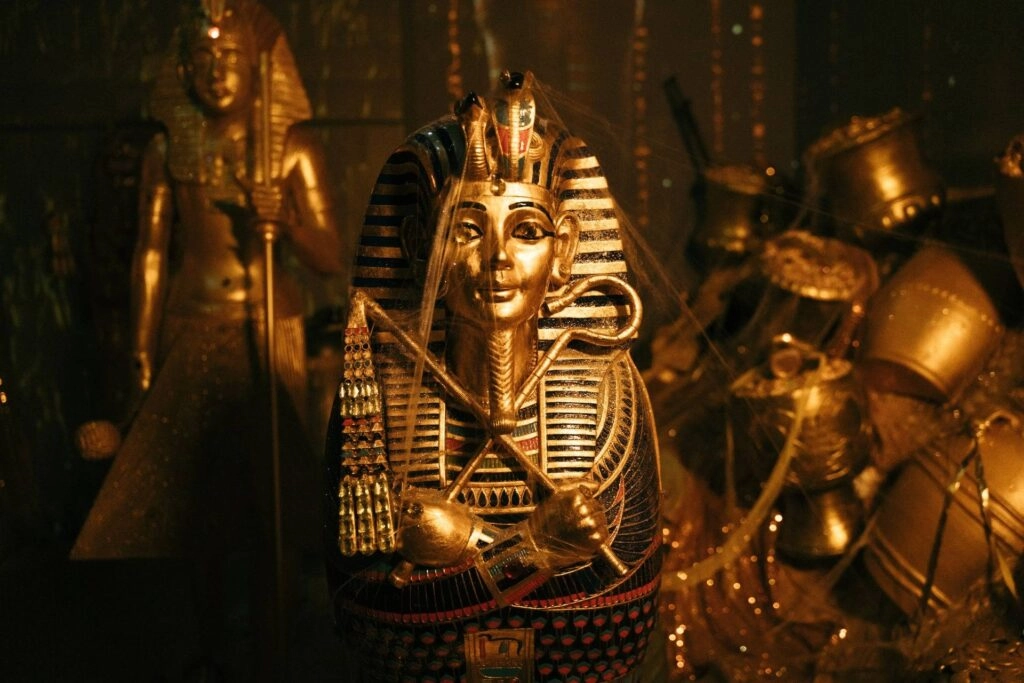 Golden statue of ancient Egyptian pharaoh with crossed arms and traditional headdress